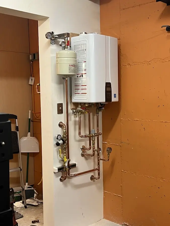 Plumbing technician inspecting water heater connections in Gladstone